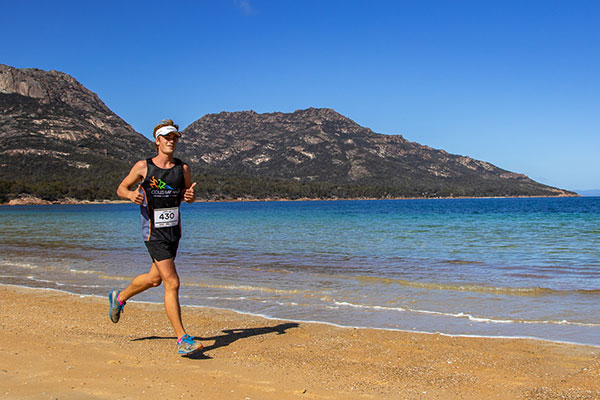 Trail running along the beach in the Freycinet Challenge